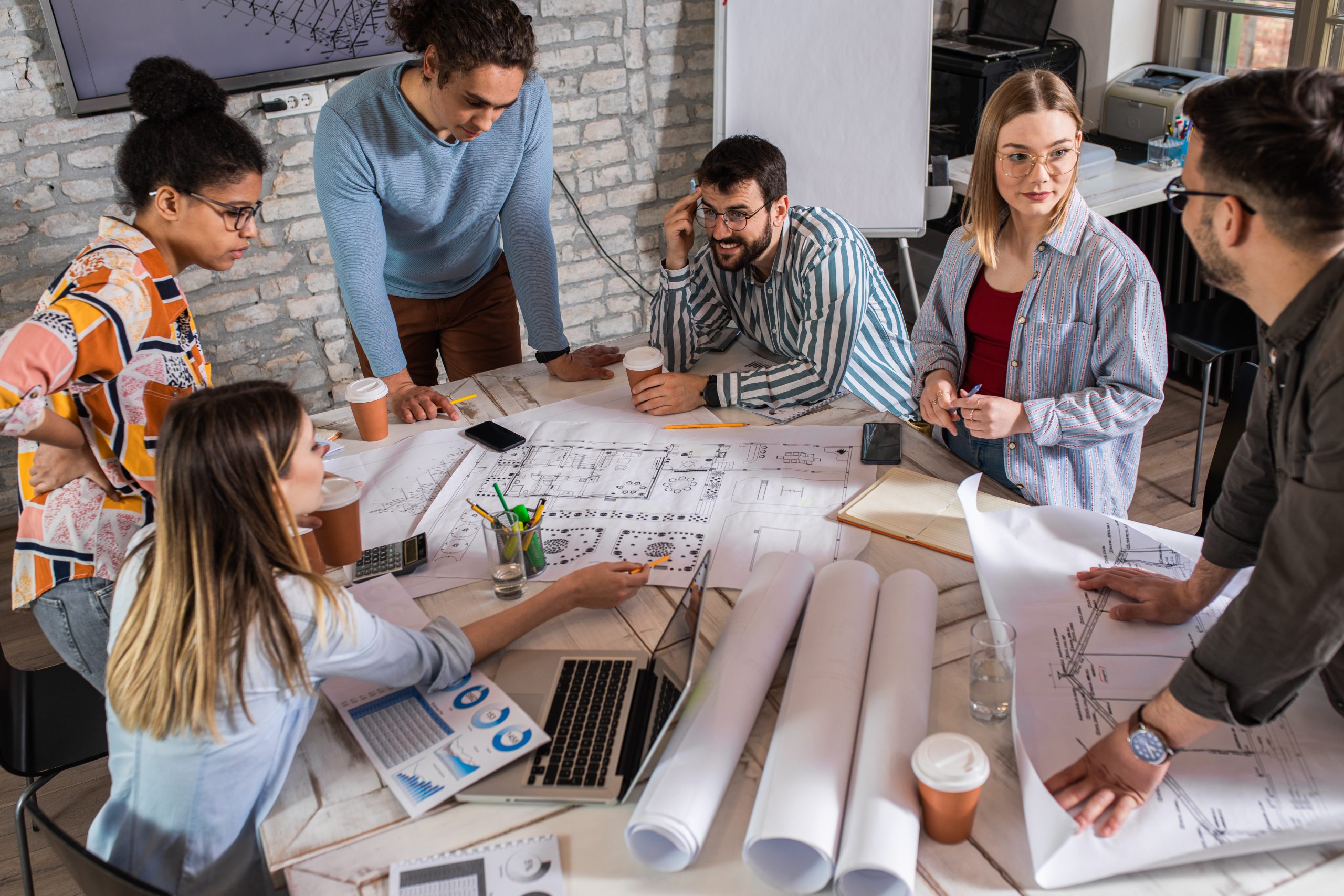 Group of modern business people discussing architectural designs